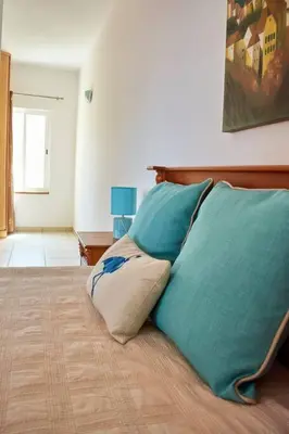 a bed with two pillows on top of it at Apartamento T3 encantador com piscina wifi e perto de praia in Santa Maria