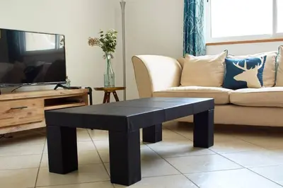 a living room with a black coffee table and a couch at Apartamento T3 encantador com piscina wifi e perto de praia in Santa Maria