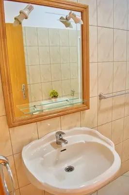 a bathroom with a white sink and a mirror at Apartamento T3 encantador com piscina wifi e perto de praia in Santa Maria