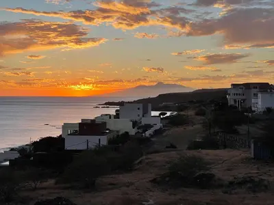 a sunset over the ocean with houses on a hill at Chambre 3 Residencial Eunice in Praia