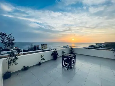 a balcony with a table and a view of the ocean at Chambre 3 Residencial Eunice in Praia