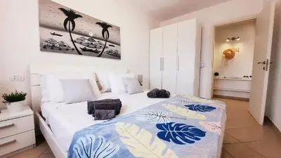 a bedroom with a bed with a blue and white blanket at Sunshine home Sal in Santa Maria