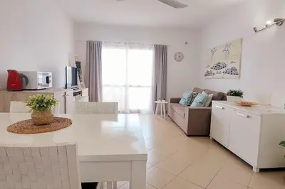 a white living room with a couch and a kitchen at Sunshine home Sal in Santa Maria