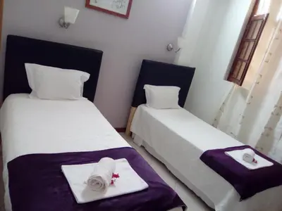 two beds in a room with towels on them at Atlantic Maio Hotel in Vila do Maio