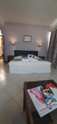 a bedroom with a bed and a table in front of it at Atlantic Maio Hotel in Vila do Maio