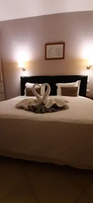 a bed with a white ribbon on top of it at Atlantic Maio Hotel in Vila do Maio