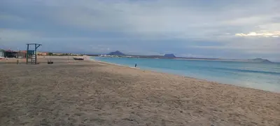 a sandy beach with a lifeguard tower and the ocean at Ka-Bela 2 in Sal Rei