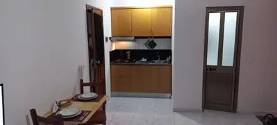 a kitchen with wooden cabinets and a table and a dining room at Ka-Bela 2 in Sal Rei
