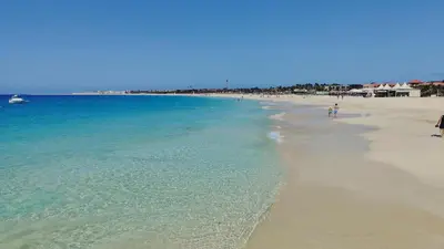 a beach with people walking on the sand and the water at Albis Harena - Meridiana Private Apartment Ocean View in Santa Maria