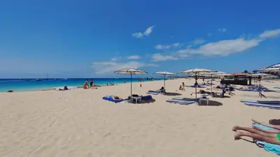 a group of people sitting on a beach with umbrellas at Albis Harena - Meridiana Private Apartment Ocean View in Santa Maria