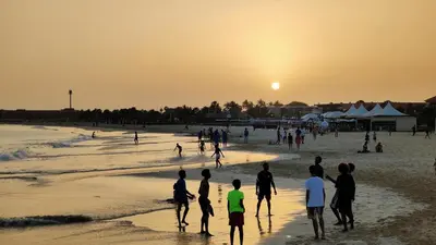 a group of people playing on the beach at sunset at Albis Harena - Meridiana Private Apartment Ocean View in Santa Maria