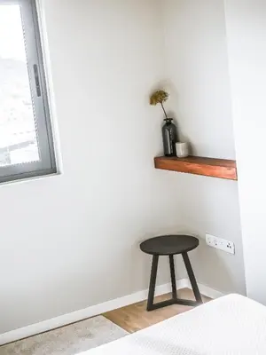 a stool sitting in a room next to a window at Madeira apartment in Mindelo São Vicente in Mindelo