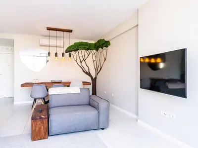 a living room with a blue chair and a table at Madeira apartment in Mindelo São Vicente in Mindelo