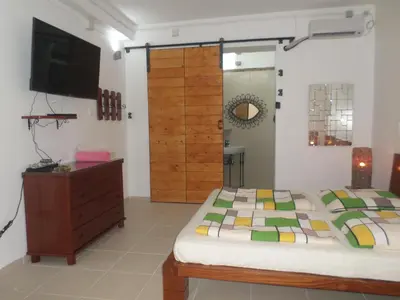 a bedroom with a bed and a dresser and a television at Casa Privada do Plateau in Praia
