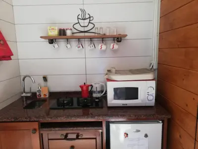 a small kitchen with a microwave and a sink at Casa Privada do Plateau in Praia