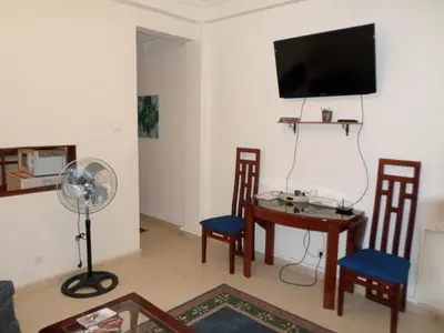 a living room with a table and a flat screen tv at Casa Privada do Plateau in Praia