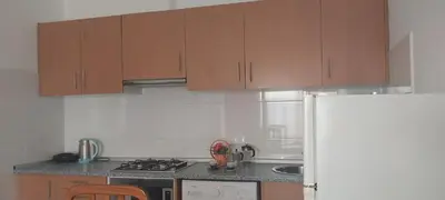 a kitchen with wooden cabinets and a stove and a refrigerator at Ca’ Tina in Santa Maria