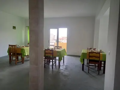 a dining room with tables and chairs with green table cloth at Residencial Rosa Criola in Sal Rei