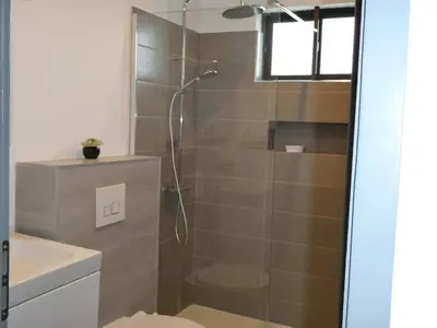 a bathroom with a shower with a glass door at Praia Center in Praia