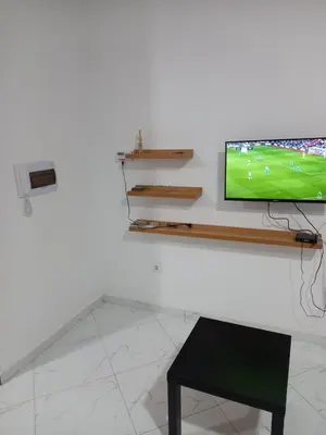 a television sitting on top of a white table at Figo Apartamentos in Praia