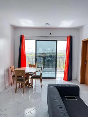 a living room with a table and chairs and a window at Figo Apartamentos in Praia
