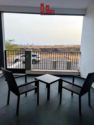 a patio with two chairs and a table and a balcony at Figo Apartamentos in Praia