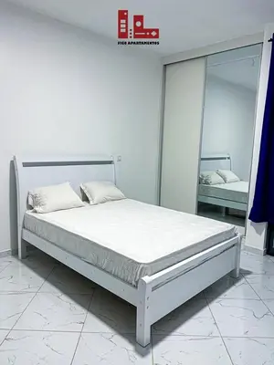 a white bedroom with a bed and a mirror at Figo Apartamentos in Praia