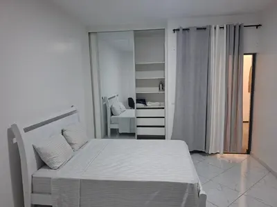 a white bedroom with a bed and a mirror at Figo Apartamentos in Praia