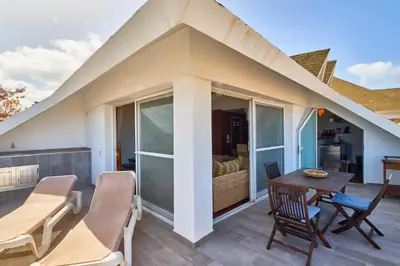 a balcony with a table and chairs and a bedroom at Leme Bedje Sea View - By Bobbywashere in Santa Maria