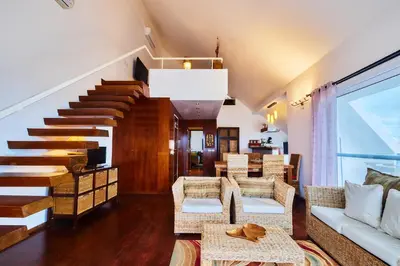 a living room with a couch and a staircase at Leme Bedje Sea View - By Bobbywashere in Santa Maria