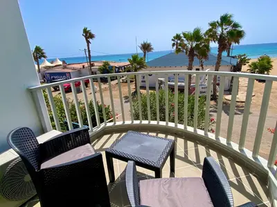 a balcony with chairs and a table and the beach at Leme Bedje Sea View - By Bobbywashere in Santa Maria