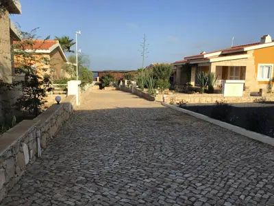 a cobblestone street in a town with houses at Casita Solemar direkt am Atlantik in Vila do Maio