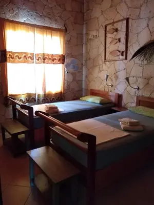 a bedroom with two beds and a window at Casita Solemar direkt am Atlantik in Vila do Maio