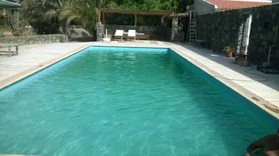 a swimming pool with blue water in a yard at Villa Morabeza Guest House in Mindelo