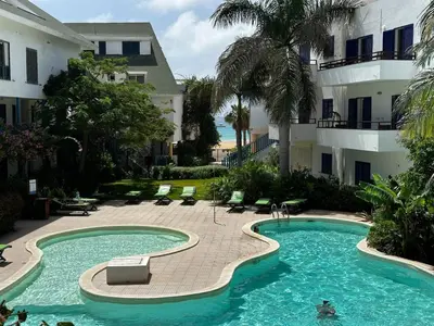 a swimming pool in front of a building at Leme Bedje Three bedroom - By Bobbywashere in Santa Maria