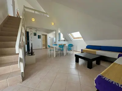a room with a staircase and a couch and a table at Leme Bedje Three bedroom - By Bobbywashere in Santa Maria