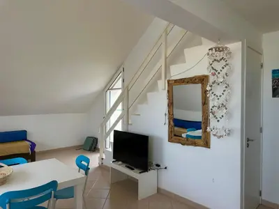 a living room with a tv and a table and a mirror at Leme Bedje Three bedroom - By Bobbywashere in Santa Maria
