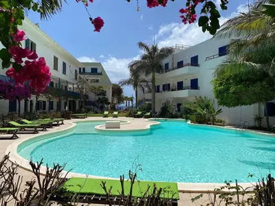 a large swimming pool in front of a building at Leme Bedje Three bedroom - By Bobbywashere in Santa Maria
