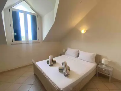 a bedroom with a large bed with a window at Leme Bedje Two bedroom - By Bobbywashere in Santa Maria