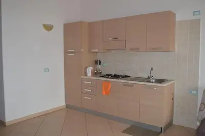 a kitchen with wooden cabinets and a sink at Holiday Properties Soleil Penthouse in Santa Maria