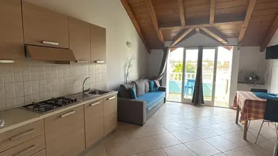 a kitchen with a stove and a couch and a table at Holiday Properties Soleil Penthouse in Santa Maria
