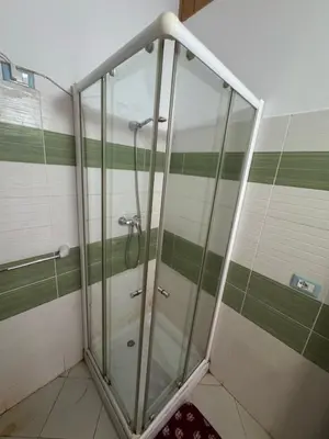 a shower in a bathroom with green and white stripes at Holiday Properties Soleil Penthouse in Santa Maria