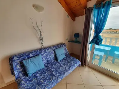 a blue couch in a room with a window at Holiday Properties Soleil Penthouse in Santa Maria