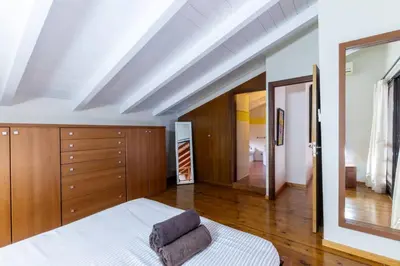 a bedroom with a white bed and wooden cabinets at Porto Antigo 1 - Three bedroom, pool & wifi in Santa Maria