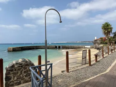 a street light next to a beach with the ocean at Porto Antigo 1 - Three bedroom, pool & wifi in Santa Maria