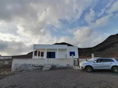 a car parked in front of a white house at Villa Calhau in Mindelo
