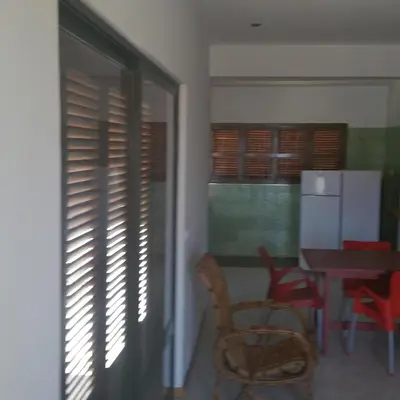 a dining room with a table and chairs and a window at Villa Calhau in Mindelo