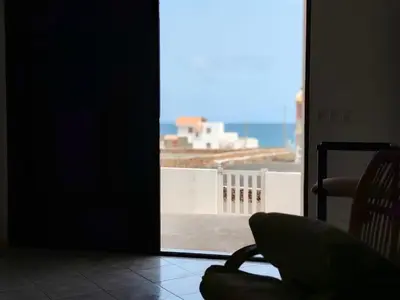a room with a chair and a view of the ocean at Villa Calhau in Mindelo