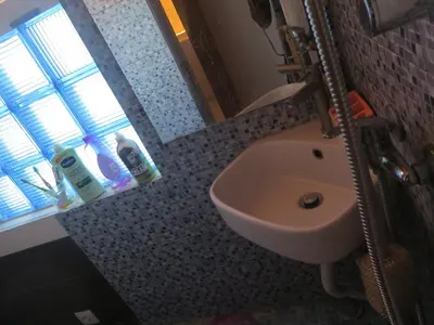 a bathroom with a white sink and a window at Casa de Nômades Digitais in Mindelo