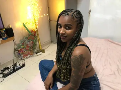 a woman with a tattoo on her arm sitting on a bed at Casa de Nômades Digitais in Mindelo